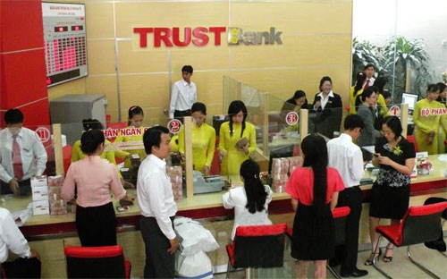 Giao dịch tại TrustBank. Ngân hàng này cho biết đang tập trung sử dụng nguồn lực từ các tập đoàn, tổ chức, cá thể kinh tế tư nhân trong nước để tái cơ cấu.