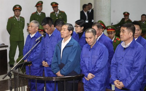 Bị cáo Dương Chí Dũng (giữa) và 9 bị cáo đồng phạm đứng trước vành móng ngựa - Ảnh: TTXVN.