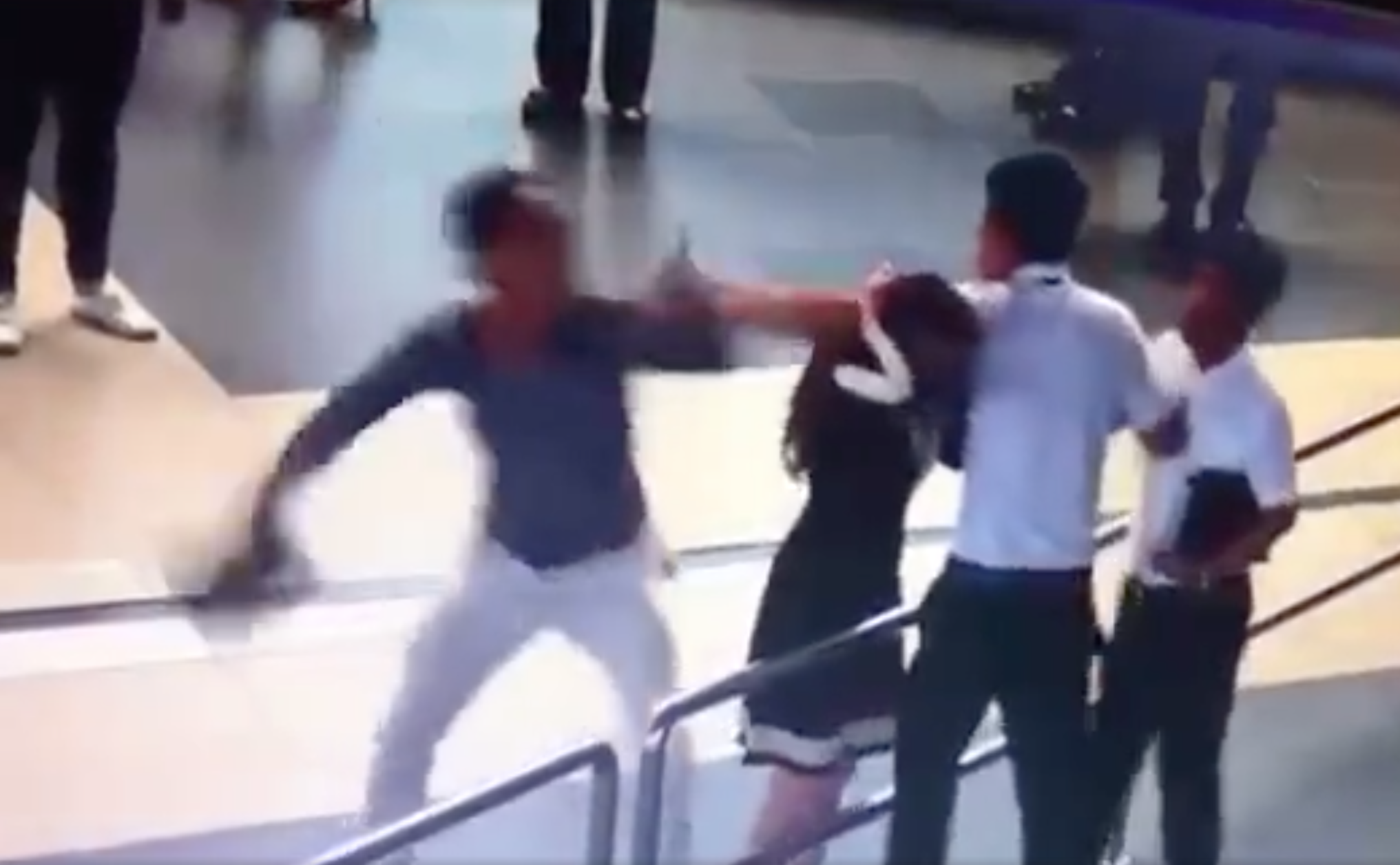 Hình ảnh nữ nhân viên bị hai hành khách hành hung, được cắt từ clip ghi lại vụ việc.