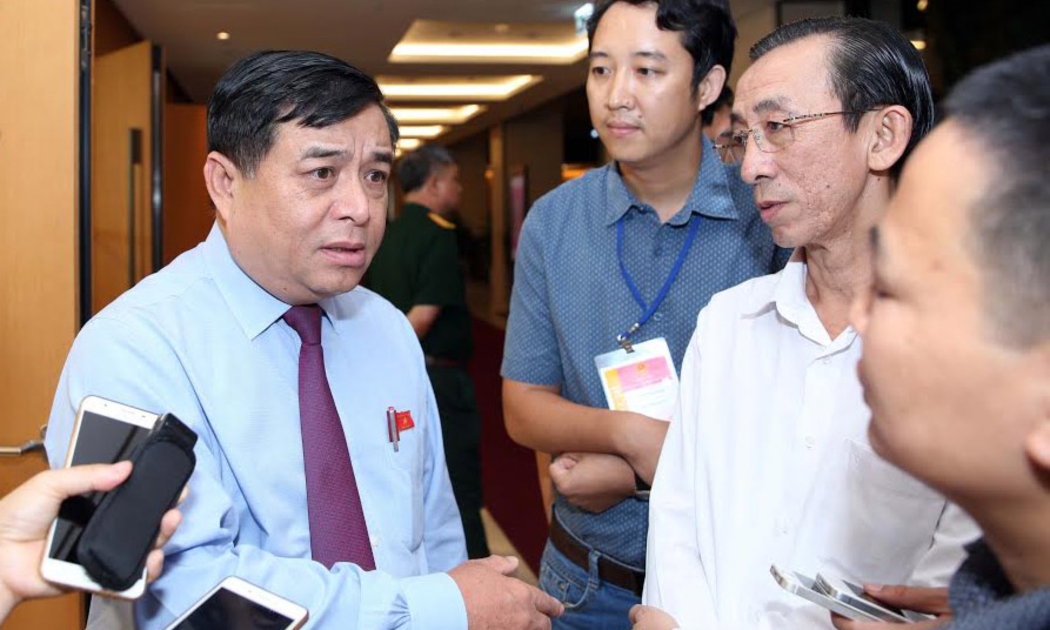Bộ trưởng Bộ Kế hoạch và Đầu tư Nguyễn Chí Dũng trao đổi với báo chí bên hành lang Quốc hội sáng 12/6.<br>