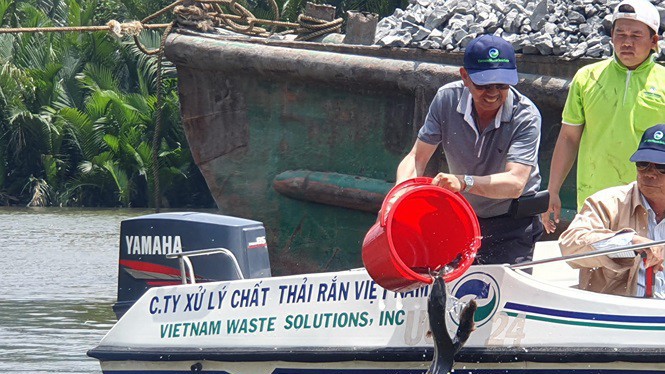 Ông David Duong và cán bộ nhân viên Công ty VWS cùng thả cá xuống kênh Rạch Chiếu, sông Cần Giuộc.