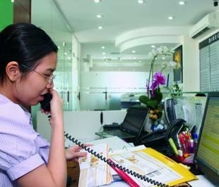 Nhân viên của một công ty cung cấp dịch vụ văn phòng ảo trực điệ thoại cho khách thuê. Ảnh: Lê Toàn.