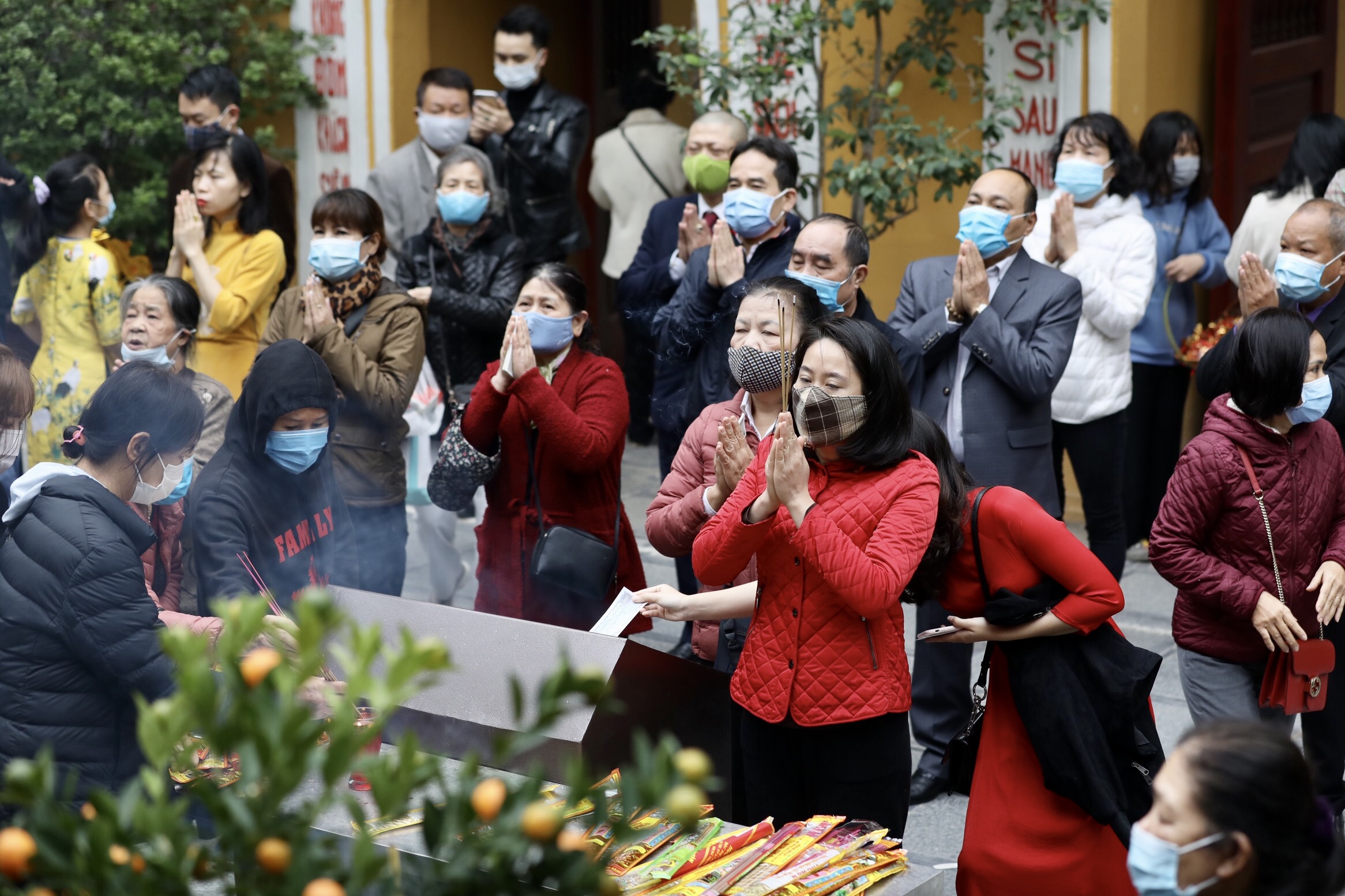 Người dân lễ chùa vào ngày đầu tiên của năm Tân Sửu tại Hà Nội. Tất cả đều đeo khẩu trang để phòng dịch - Ảnh: VGP