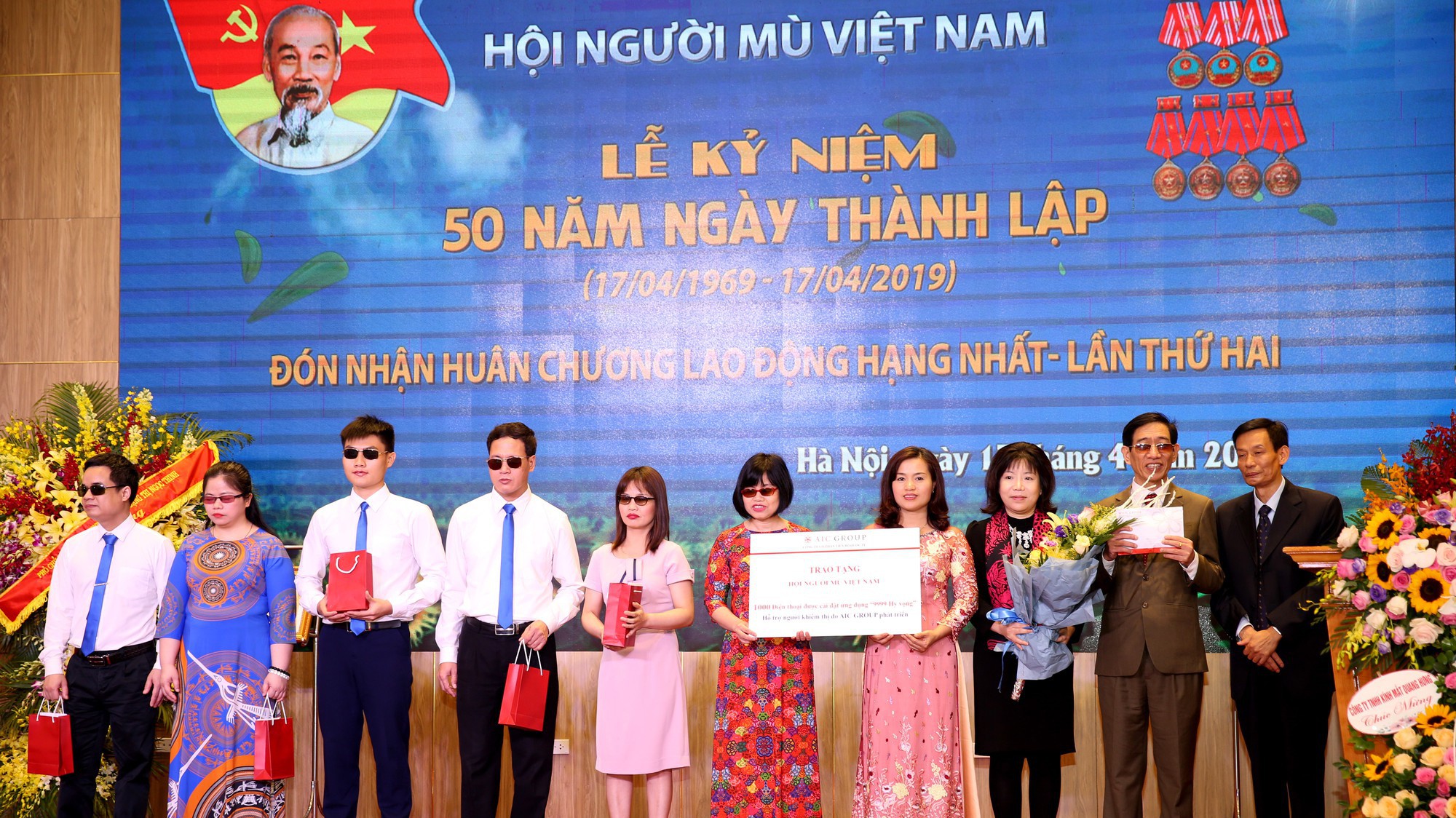 Bà Nguyễn Thị Thanh Nhàn - Chủ tịch hội đồng quản trị kiêm Tổng giám đốc tập đoàn AIC Group trao tặng 1000 điện thoại và 100 triệu đồng cho Hội người mù Việt Nam.
