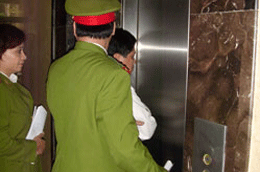 Công an đang áp giải ông Dũng (áo trắng) tại trụ sở BIDV - Ảnh: Thái Sơn.