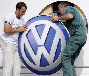 Công nhân đang lắp logo của Volkswagen vào một pa nô quảng cáo. Trong nửa đầu năm nay, thị phần toàn cầu thuộc về hãng xe lớn nhất châu Âu của Đức này đã tăng lên mức 12% từ mức 9,9% cùng kỳ năm ngoái - Ảnh: Getty.
