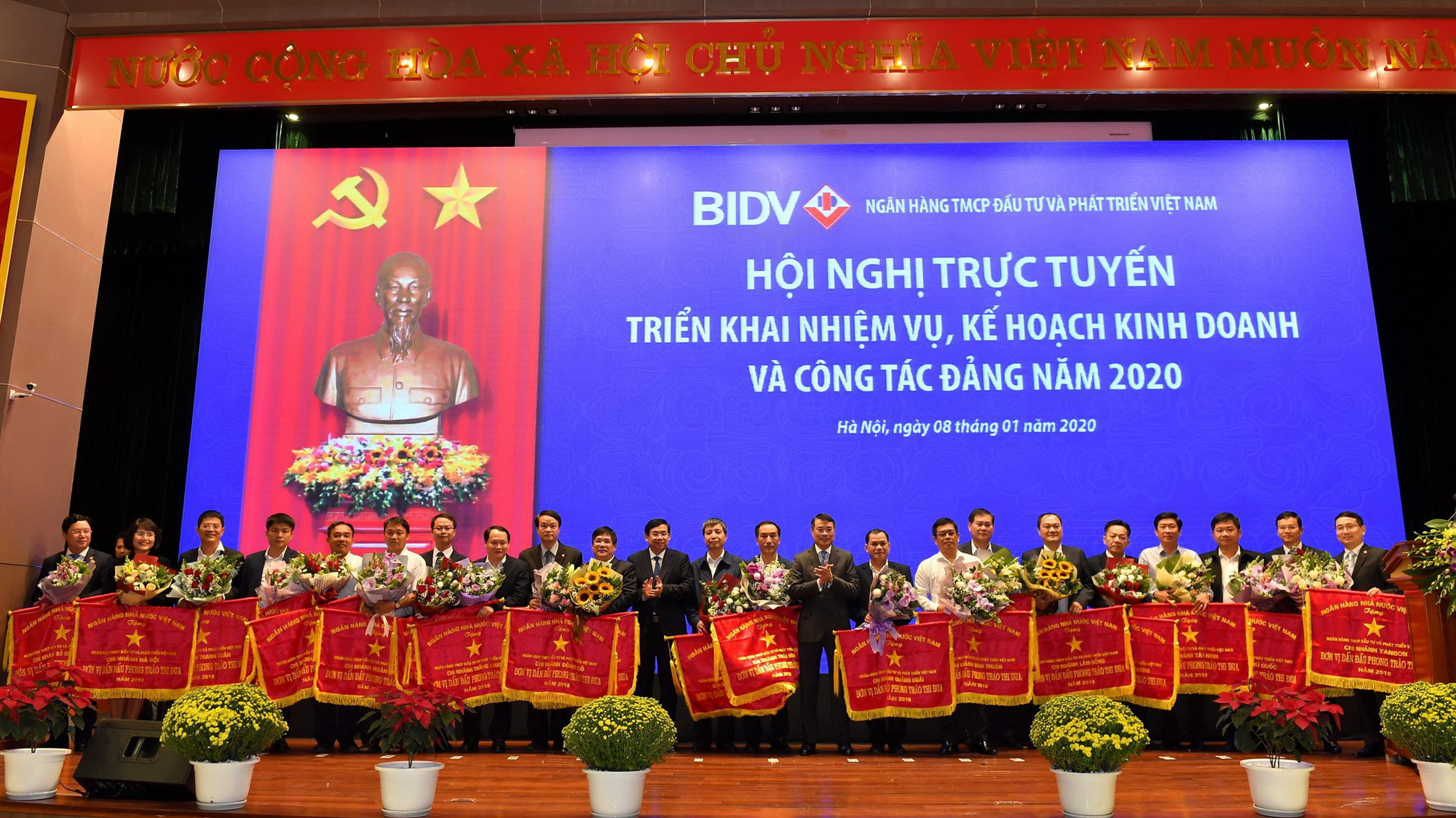 Thống đốc Lê Minh Hưng tặng cờ thi đua của Ngân hàng Nhà nước cho các tập thể, đơn vị tại BIDV.  Ảnh: Thu Hương.