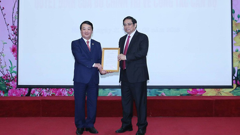 Trưởng ban Tổ chức Trung ương Phạm Minh Chính trao quyết định của Bộ Chính trị cho ông Hầu A Lềnh (trái).