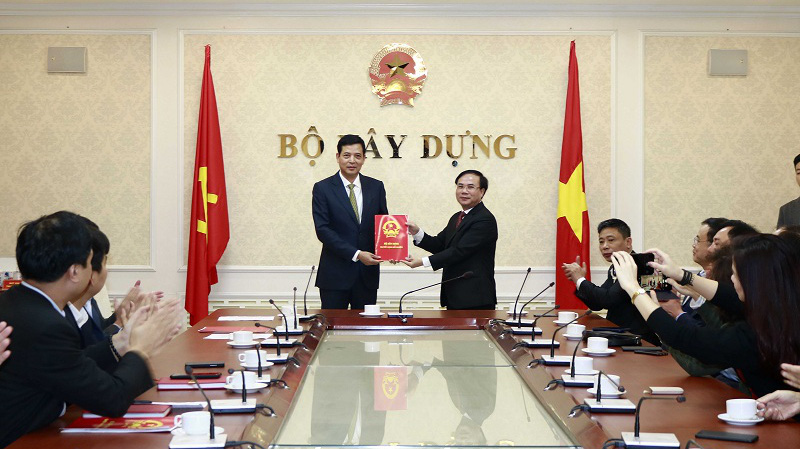 Thứ trưởng Nguyễn Văn Sinh trao Quyết định của Bộ trưởng Bộ Xây dựng bổ nhiệm ông Bùi Xuân Dũng (bên trái) giữ chức vụ Cục trưởng Cục Quản lý nhà & thị trường bất động sản.