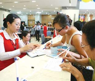 Khách hàng giao dịch tại Sacombank - Ảnh: Lê Toàn.