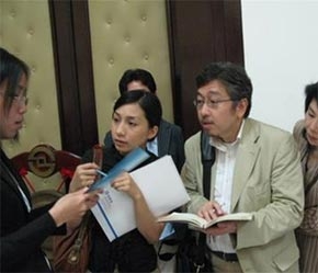 Khách du lịch Nhật thu lượm thông tin chứng khoán.