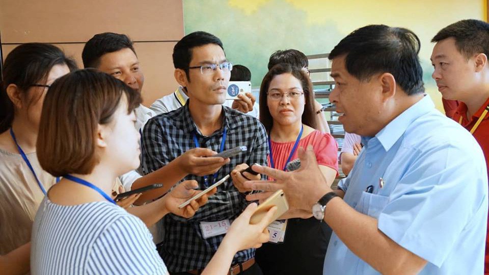 Bộ trưởng Bộ Kế hoạch và Đầu tư Nguyễn Chí Dũng trao đổi với báo chí bên hành lang Quốc hội - Ảnh: Quang Phúc 
