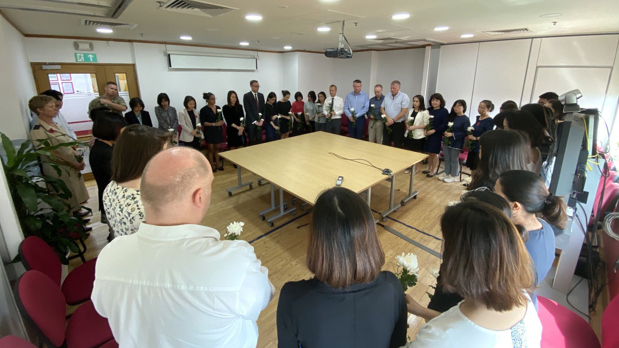 Nhân viên Đại sứ quán Anh và Tổng lãnh sự quán Anh tại Việt Nam dành một phút tưởng niệm nạn nhân vụ container - Ảnh: Facebook.