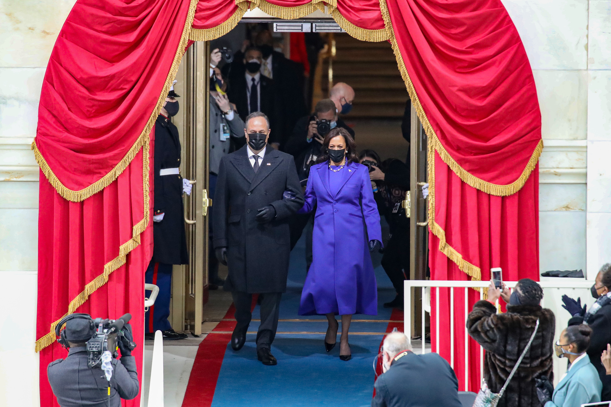 Bà Kamala Harris làm nên lịch sử khi trở thành nữ phó tổng thống da màu đầu tiên và người gốc Á đầu tiên giữ cương vị này. Bà xuất hiện với trang phục màu tím cùng phu quân Doug Emhoff - Ảnh: AP