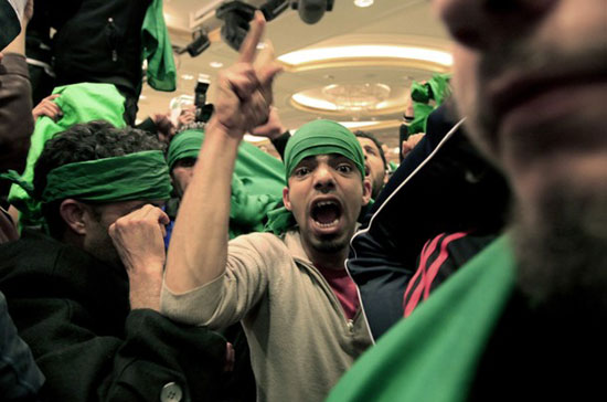 Một người ủng hộ Tổng thống Lybia đang hô khẩu hiệu tại thủ đô Tripoli hôm 18/3 - Ảnh: Reuters.