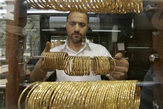 Một người thợ kim hoàn người Jordani đang sắp xếp sản phẩm tại cửa tiệm nằm ở thành phố Amman - Ảnh: Reuters.