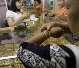 Sự lao dốc của thị trường chứng khoán toàn cầu một mặt thúc đẩy giới đầu tư chuyển vốn sang thị trường vàng để tìm kiếm sự an toàn, nhưng mặt khác cũng đang phần nào buộc các nhà đầu tư phải bán vàng ra để có tiền mặt bù lỗ - Ảnh: AP.