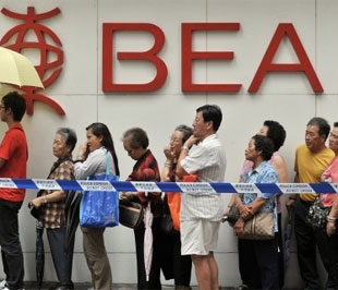 Khách hàng xếp hàng trước một chi nhánh của BEA để rút tiền ngày 24/9 - Ảnh: AFP.