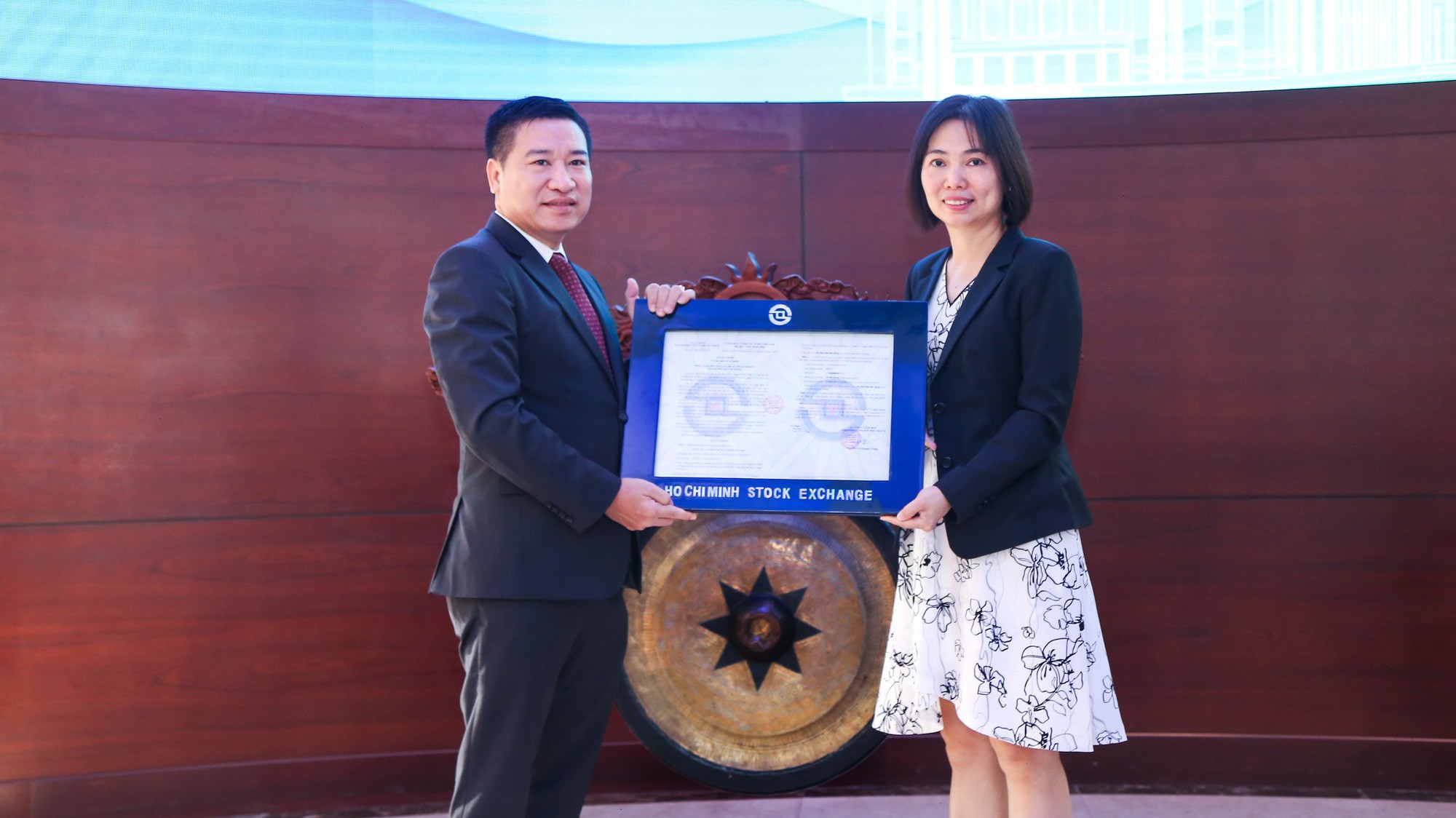 Ông Nguyễn Đình Trung - Chủ tịch Hội đồng Quản trị Công ty Cổ phần Hưng Thịnh Incons nhận quyết định niêm yết từ bà Trần Anh Đào - Phó tổng giám đốc Sở Giao dịch Chứng khoán Tp.HCM.