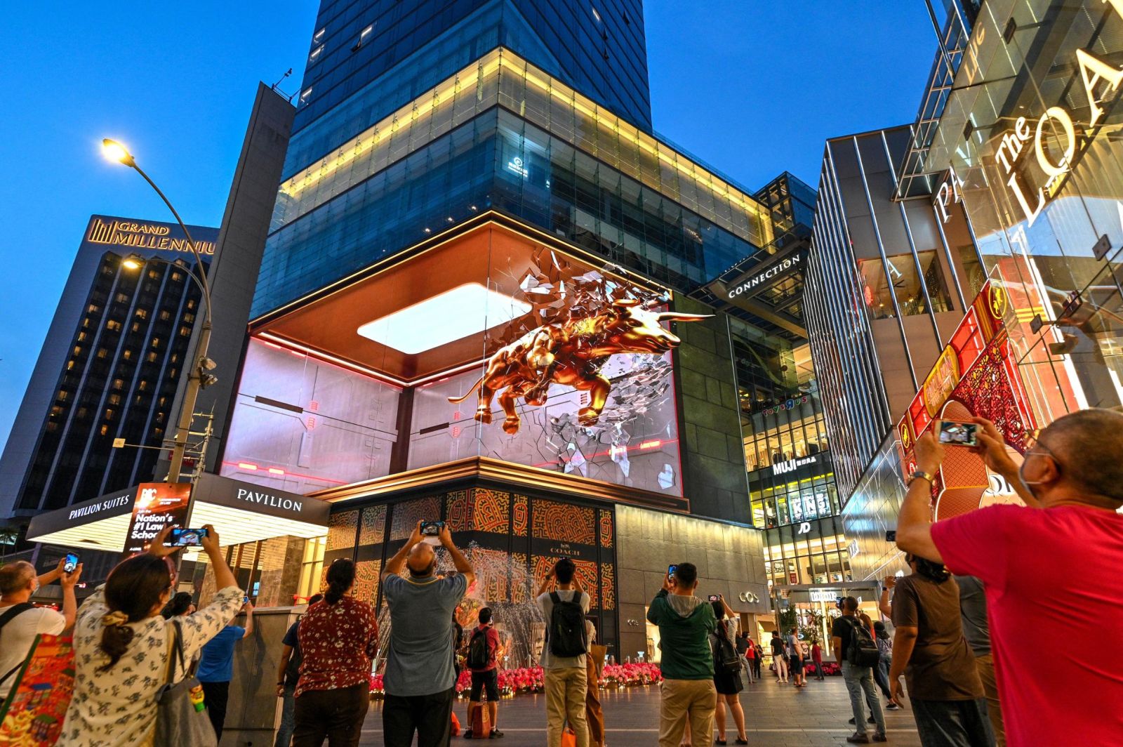 Người dân chụp ảnh màn hình 3D bên ngoài một trung tâm mua sắm tại Kuala Lumpur, Malaysia ngày 11/2 - Ảnh: Xinhua/Getty Images