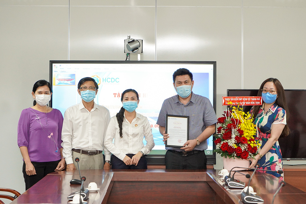 Đại diện Ban Thường trực Ủy ban Mặt trận Tổ quốc - Ban vận động, tiếp nhận và phân phối Quỹ phòng, chống dịch Covid-19 Thành phố, HCDC cùng Sở Y tế Tp.HCM tặng hoa và thư cảm ơn cho đại diện Tập đoàn Hưng Thịnh.