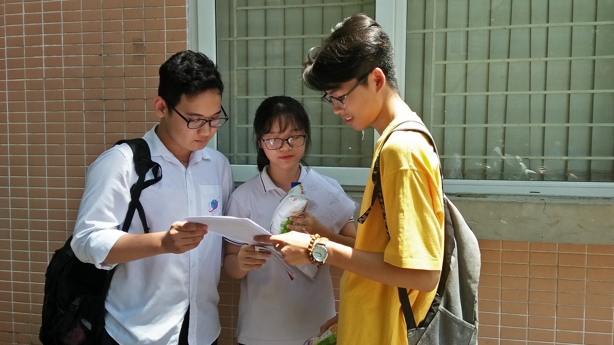 Thí sinh trao đổi kết quả sau buổi sáng kết thúc tổ hợp bài thi Khoa học tự nhiên, sáng 26/6. Ảnh: Thu Hằng. 