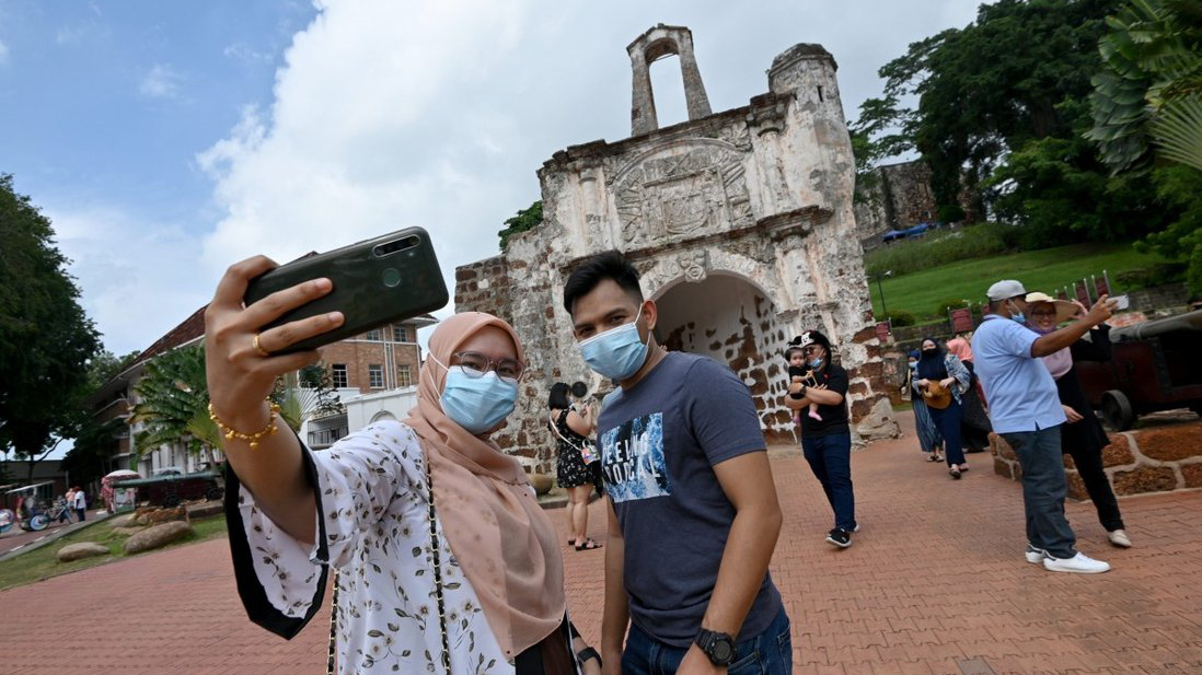 Du khách chụp ảnh tại một điểm du lịch tại Malacca, Malaysia, vào tháng 12/2020 - Ảnh: Xinhua