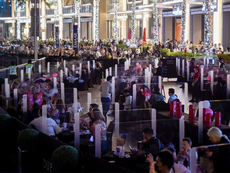 Thực khách ăn uống tại trung tâm thương mại Dubai Mall Promenade và chờ xem pháo hoa bắn gần Burj Khalifa. Tất cả phải duy trì giãn cách xã hội để phòng dịch - Ảnh: Gulf News