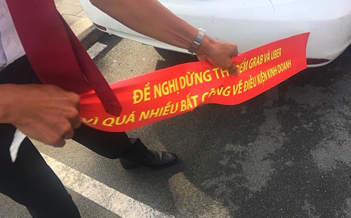 Nhiều hãng taxi dán khẩu ngữ phản đối Uber, Grab bị buộc phải gỡ bỏ.