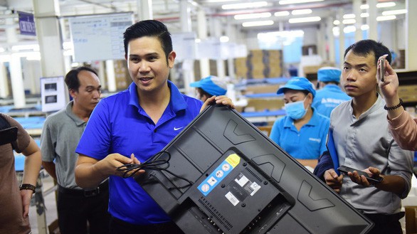 Chủ tịch Tập đoàn điện tử Asanzo Phạm Văn Tam giới thiệu về quy trình sản xuất tivi tại nhà máy ở Khu công nghiệp Vĩnh Lộc, Q.Bình Tân, TP.HCM chiều 23/6 - Ảnh: Tuổi trẻ.