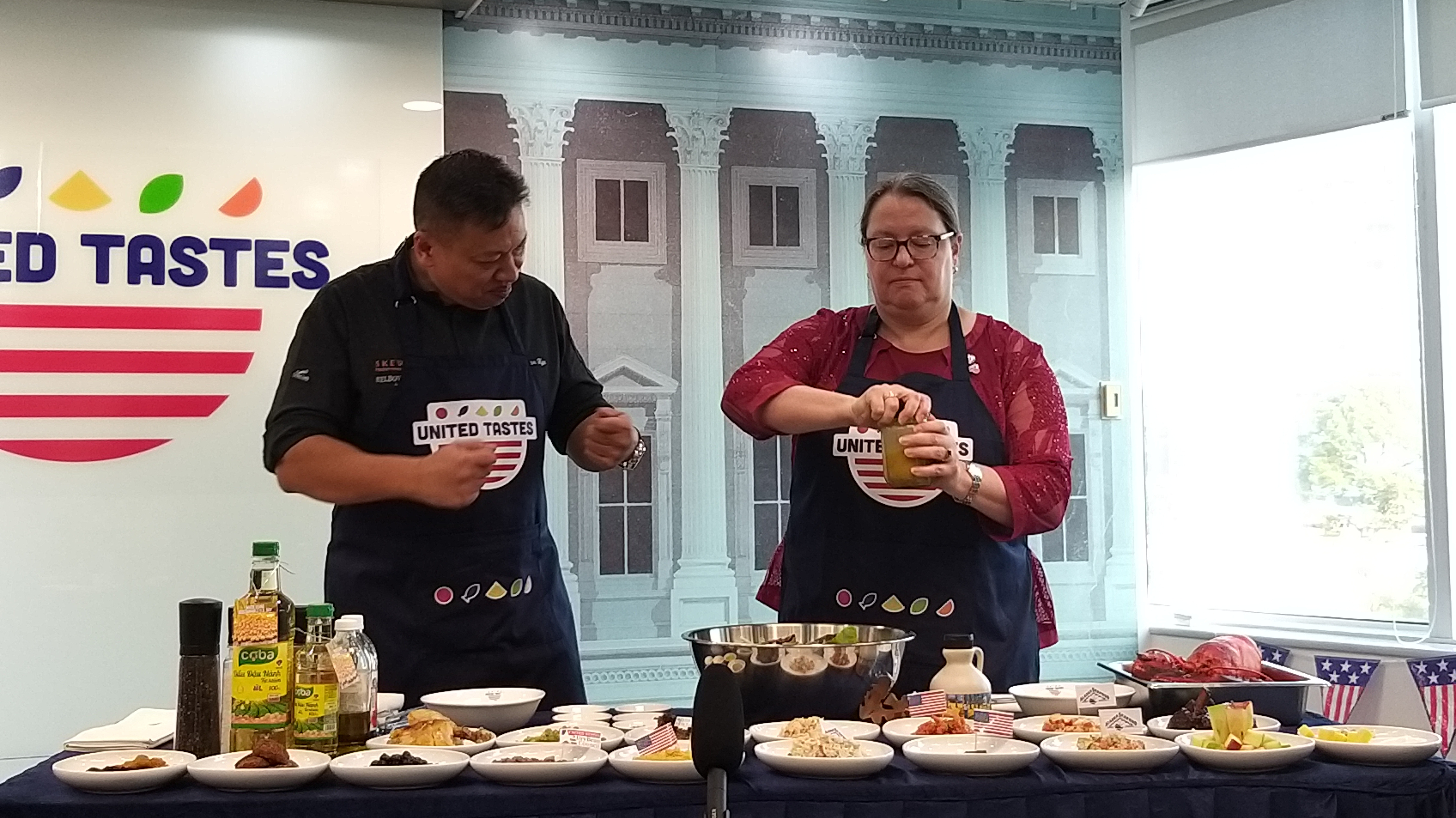 Bà Marie C.Damour, Tổng Lãnh sự Hoa Kỳ tại Tp.HCM (bên phải) cùng đầu bếp Tristan Ngo cùng thực hiện món salad.