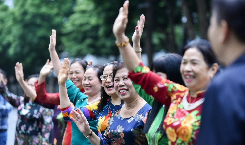 Nhiều người mặc áo dài có mặt từ sớm vẫy chào thủ tướng Nhật - Ảnh: TGVN.