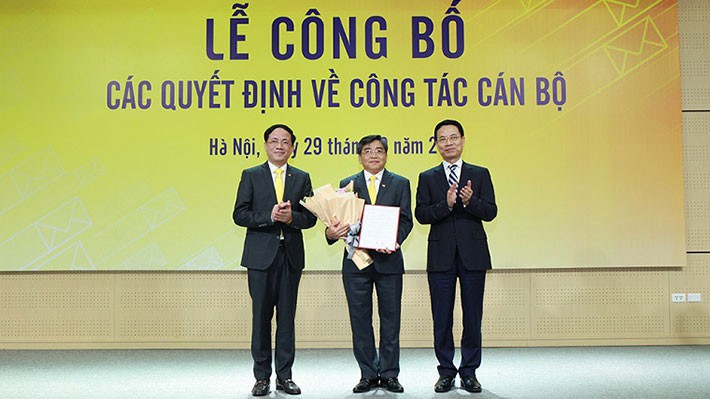 Bộ trưởng Nguyễn Mạnh Hùng (phải) trao quyết định bổ nhiệm chức vụ Chủ tịch HĐTV Tổng công ty VNPost cho ông Nguyễn Hải Thanh (giữa).
