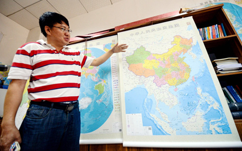 Ông Lei Yixun, giám đốc nhà xuất bản bản đồ tỉnh Hồ Nam, giới thiệu bản đồ phi pháp vừa phát hành - Ảnh: Xinhua.