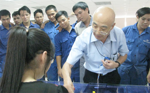 Ông Terasaki Akashi (đeo kính) thị phạm cho công nhân.<br>