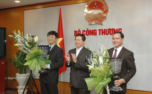 Bộ trưởng Bộ Công Thương Vũ Huy Hoàng (giữa) chúc mừng hai cán bộ được luân chuyển, tại một buổi lễ công bố quyết định của Ban Bí thư về việc điều động và luân chuyển cán bộ của Bộ Công Thương.<br>