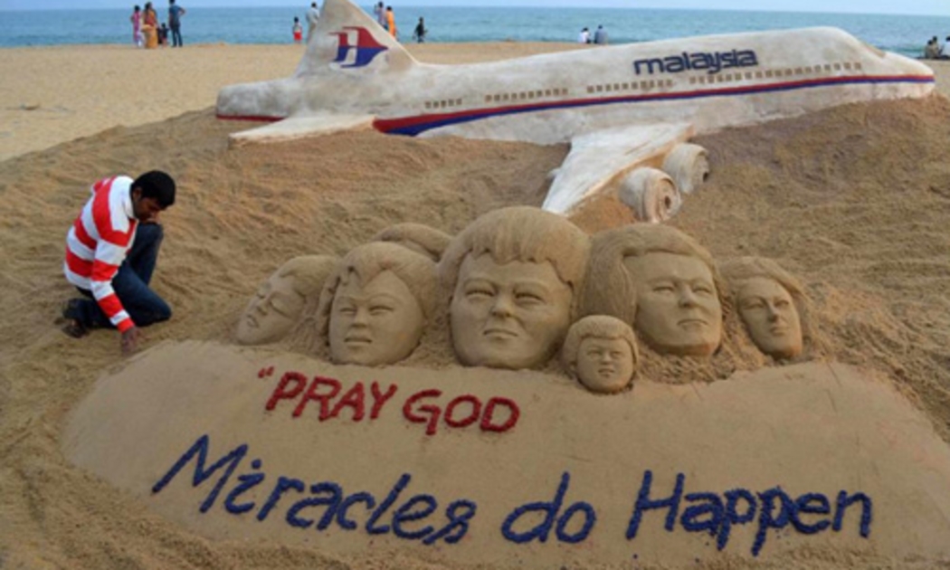 Một nghệ sỹ Ấn Độ đắp hình chuyến bay MH370 trên cát để cầu nguyện cho các hành khách và phi hành đoàn - Ảnh: Reuters.