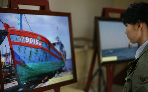 Một bạn trẻ Đà Nẵng đến xem triển lãm hình ảnh về tàu cá ĐNa 90152 bị Trung Quốc đâm chìm ngày 26/5/2014, diễn ra tại Đà Nẵng trong suốt tháng 6 vừa qua - Ảnh: TT.<br>