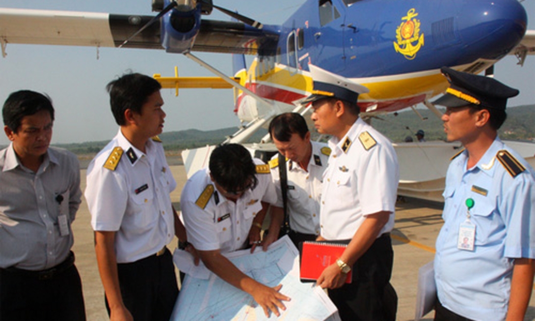 Thiếu tướng Lê Minh Thành, phó tư lệnh hải quân (thứ hai từ phải sang), hội ý với tổ bay thủy phi cơ DHC-6 tại sân bay Phú Quốc chiều 9/3, trong nỗ lực tìm kiếm máy bay mất tích của hãng Malaysia Airlines - Ảnh: Tuổi Trẻ.