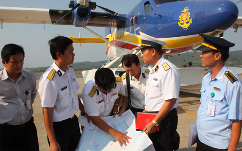 Thiếu tướng Lê Minh Thành, phó tư lệnh hải quân (thứ hai từ phải sang), hội ý với tổ bay thủy phi cơ DHC-6 tại sân bay Phú Quốc chiều 9/3, trong nỗ lực tìm kiếm máy bay mất tích của hãng Malaysia Airlines - Ảnh: Tuổi Trẻ.<br>