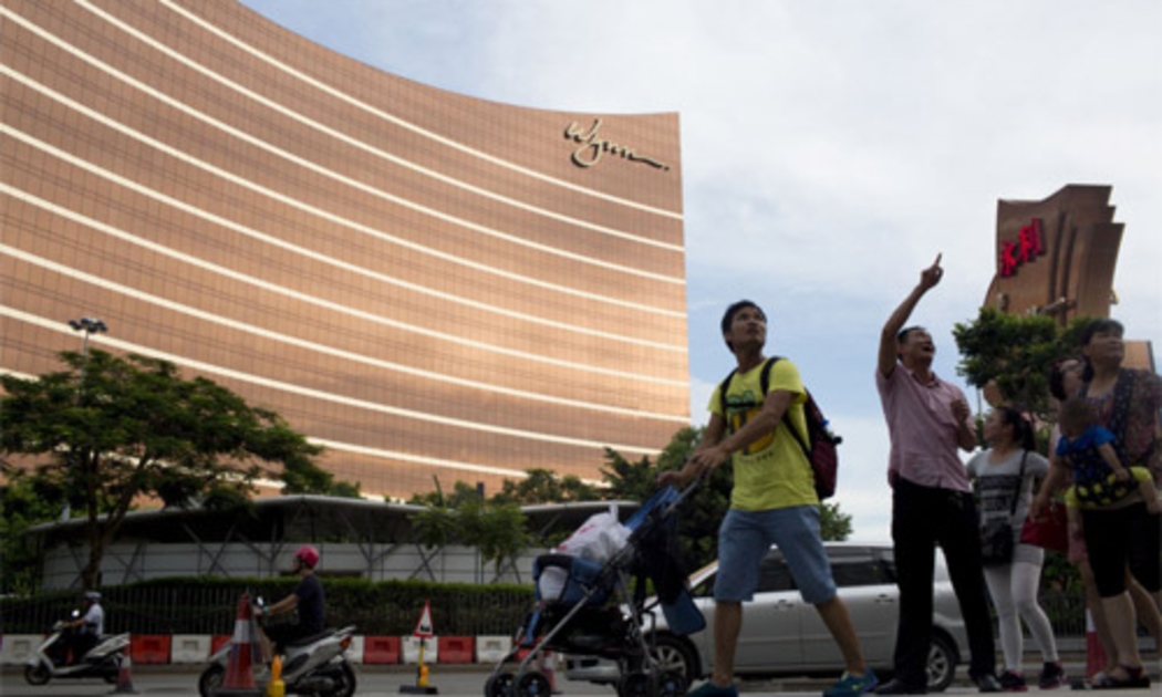 Khách du lịch đi ngang qua khu tổ hợp sòng bạc-nghỉ dưỡng Wynn Macau ở Macau - Ảnh: Bloomberg.