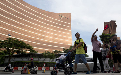 Khách du lịch đi ngang qua khu tổ hợp sòng bạc-nghỉ dưỡng Wynn Macau ở Macau - Ảnh: Bloomberg.<br>