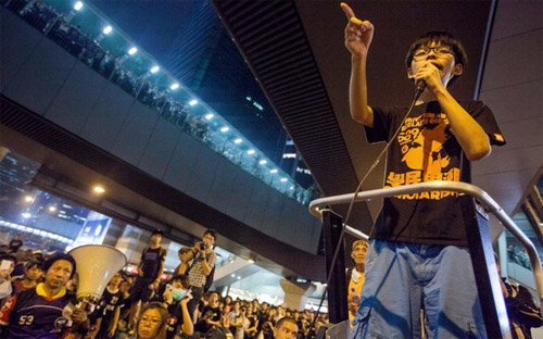 Thủ lĩnh sinh viên Hong Kong biểu tình, Joshua Wong, phát biểu trước dòng người biểu tình ngày 30/9 - Ảnh: EPA/WSJ.<br>