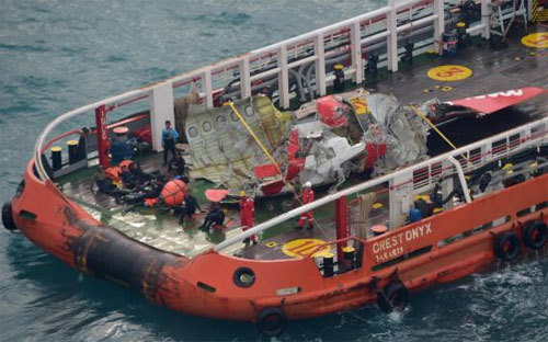 Phần đuôi máy bay AirAsia gặp nạn được trục vớt và đưa lên tàu ngày 10/1 - Ảnh: Reuters.<br>