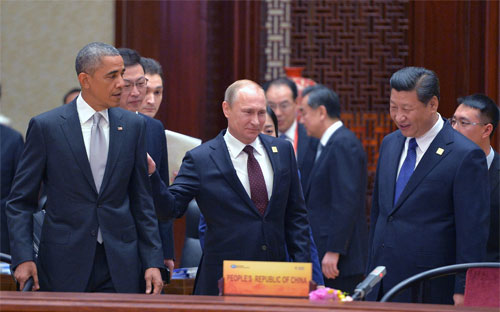 Tổng thống Mỹ Barack Obama tỏ ra lạnh lùng khi người đồng cấp Nga Vladimir Putin vỗ vào lưng ông ở Trung tâm Hội nghị Bắc Kinh hôm 10/11- Ảnh: EPA.<br>