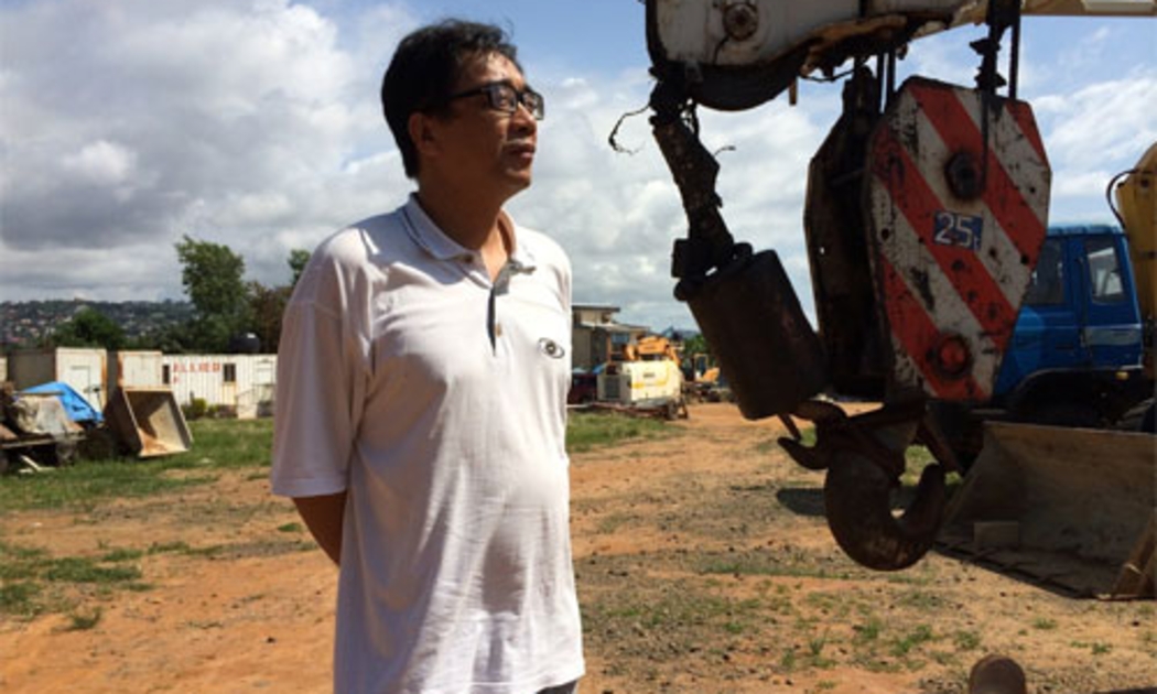Một lãnh đạo công ty xây dựng Trung Quốc đứng trên công trường dự án đã bị đình lại vì Ebola ở Sierra Leone - Ảnh: WSJ.<br>