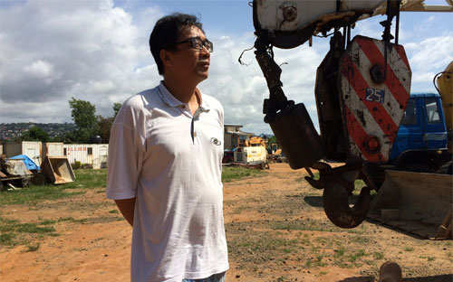 Một lãnh đạo công ty xây dựng Trung Quốc đứng trên công trường dự án đã bị đình lại vì Ebola ở Sierra Leone - Ảnh: WSJ.<br>