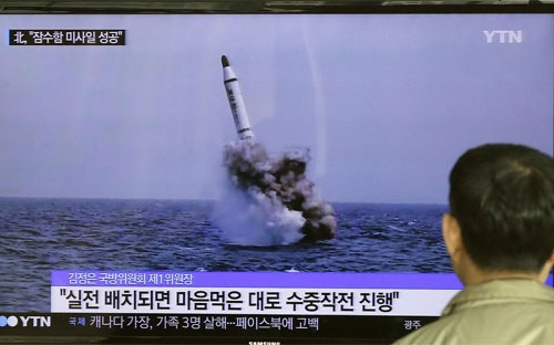 Một người Hàn Quốc xem bản tin truyền hình phát những hình ảnh do Triều Tiên công bố về vụ phóng tên lửa đạn đạo từ tàu ngầm vào cuối tuần vừa rồi - Ảnh: AP/Bloomberg.