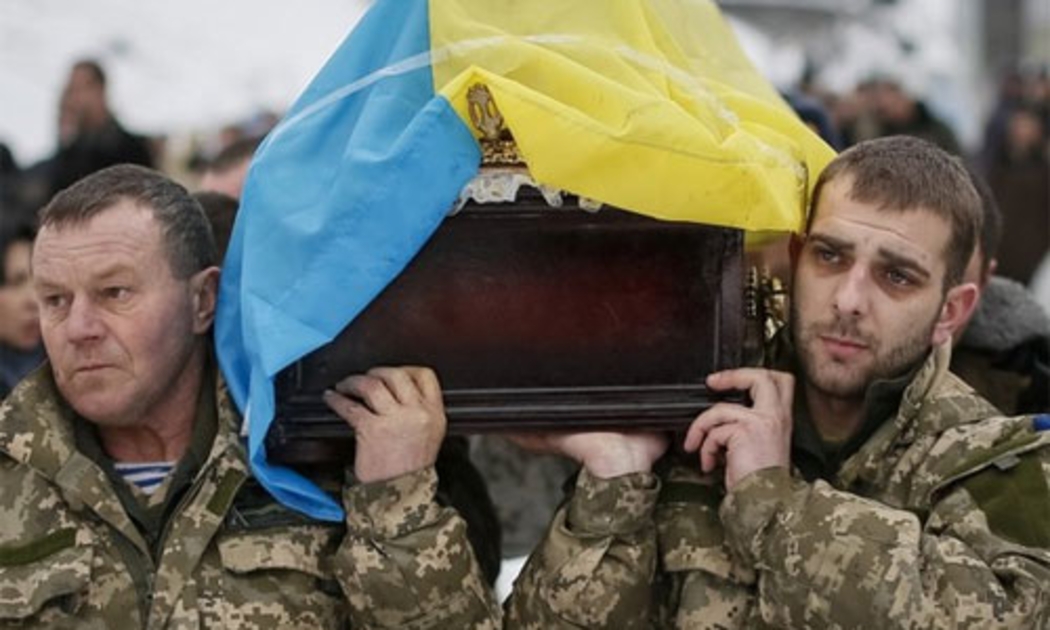 Hai binh sỹ quân đội Ukraine trong đám tang một đồng đội thiệt mạng ở miền Đông nước này hôm 20/1 - Ảnh: BBC/Reuters.<br>