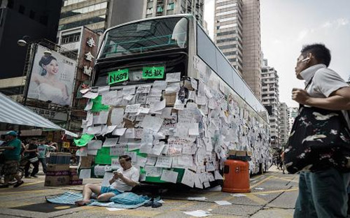 Một chiếc xe bus trên đường phố Hồng Kông ngày 30/9 dán đầy những thông điệp ủng hộ quyền dân chủ ở vùng lãnh thổ này - Ảnh: AFP.<br>